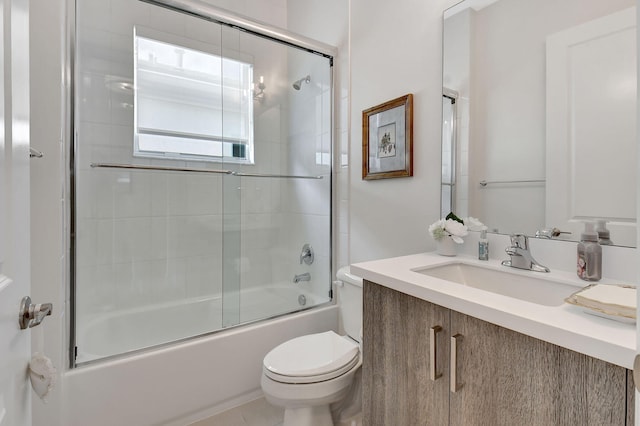 full bathroom with vanity, bath / shower combo with glass door, and toilet