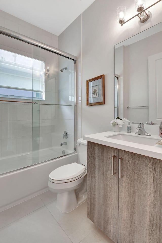 full bathroom with vanity, bath / shower combo with glass door, toilet, and tile patterned flooring