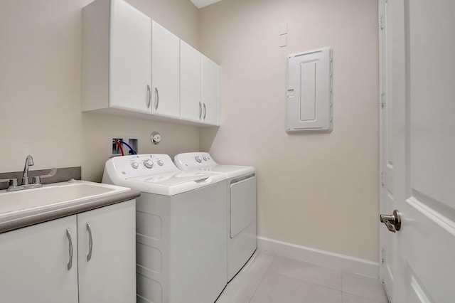 laundry area with sink, electric panel, washer and clothes dryer, cabinets, and light tile patterned floors