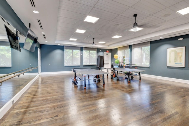 recreation room featuring a wealth of natural light, a drop ceiling, wood-type flooring, and ceiling fan