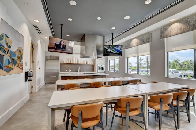 kitchen featuring a large island, a kitchen breakfast bar, stainless steel appliances, and a healthy amount of sunlight