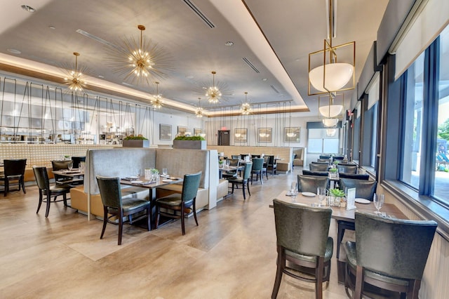 dining space featuring a notable chandelier and a raised ceiling