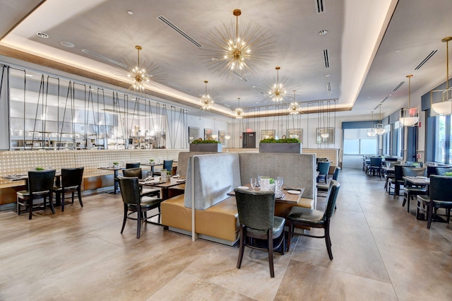 dining room with a tray ceiling and a chandelier