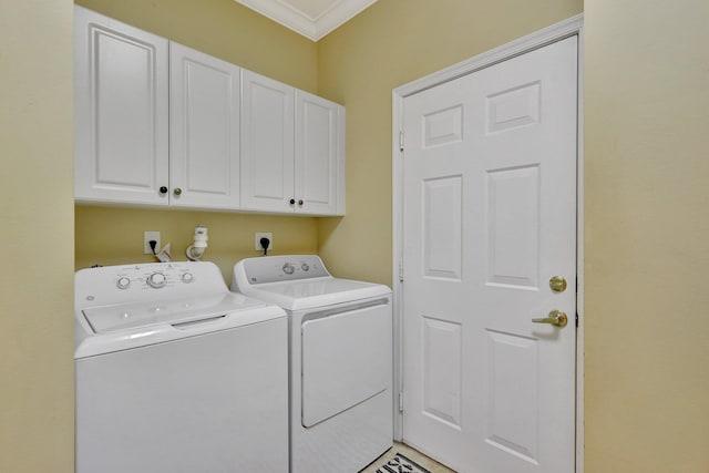 laundry room featuring washer and dryer, crown molding, and cabinets