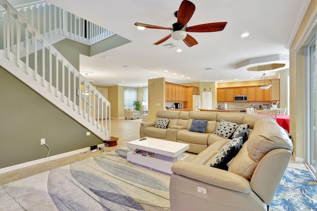 living room with crown molding, ceiling fan, and light tile patterned floors