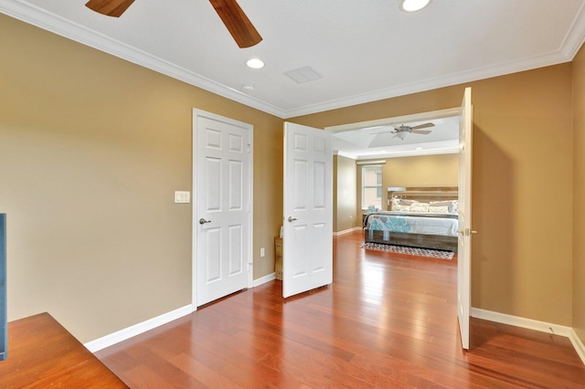 interior space featuring wood-type flooring, crown molding, and ceiling fan