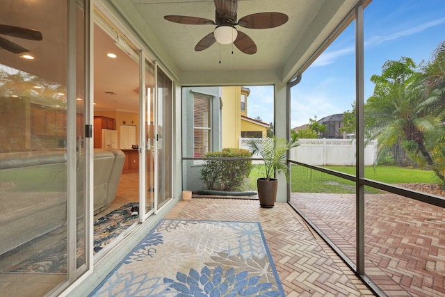 unfurnished sunroom with ceiling fan