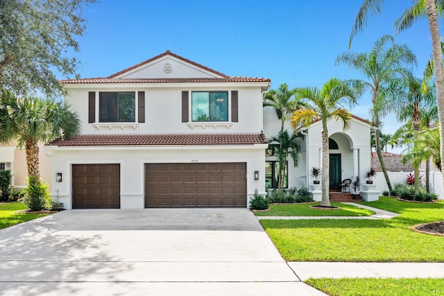 mediterranean / spanish house with a garage and a front lawn