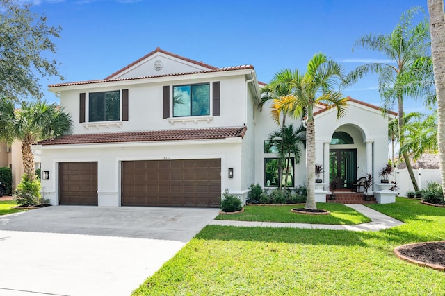 mediterranean / spanish house with a garage and a front yard