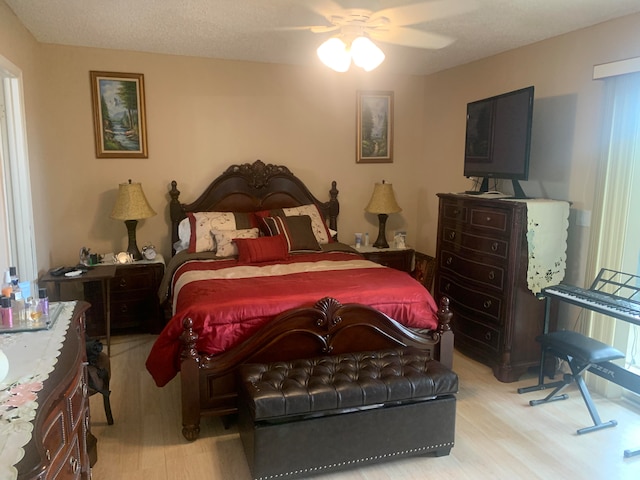 bedroom featuring light hardwood / wood-style floors, a textured ceiling, and ceiling fan