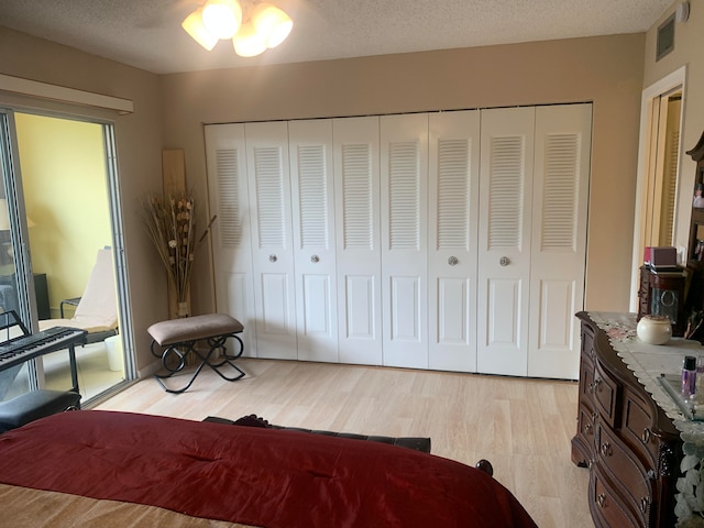 bedroom featuring light hardwood / wood-style floors, a closet, and a textured ceiling