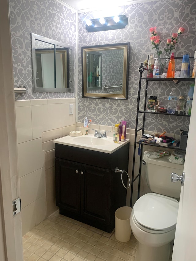 bathroom featuring tile walls, vanity, toilet, and tile patterned floors