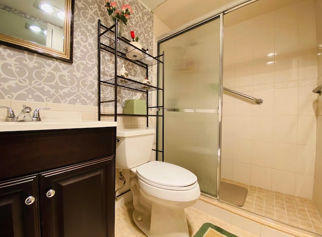 bathroom with vanity, toilet, tile patterned flooring, and an enclosed shower