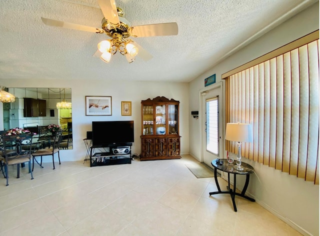 living room featuring a textured ceiling, tile patterned floors, and ceiling fan