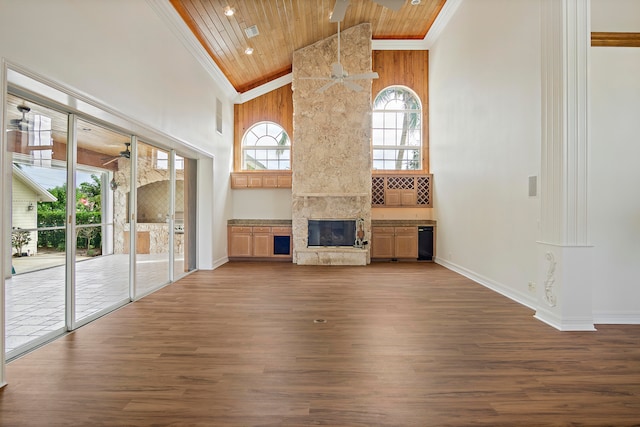 unfurnished living room with wooden ceiling, hardwood / wood-style flooring, a towering ceiling, and ceiling fan