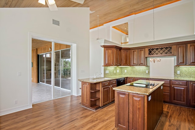 kitchen featuring ceiling fan, hanging light fixtures, kitchen peninsula, and backsplash