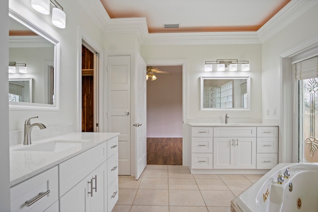 bathroom with crown molding, tile patterned floors, ceiling fan, vanity, and a washtub