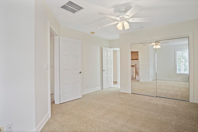 unfurnished bedroom with a closet, ceiling fan, and light carpet