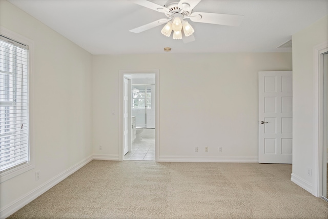 carpeted empty room featuring ceiling fan and a healthy amount of sunlight