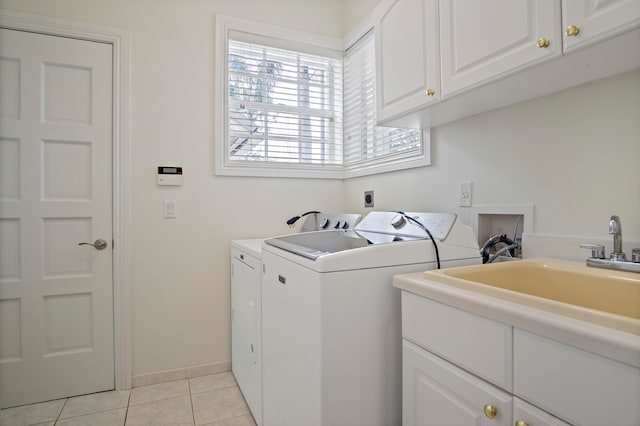 laundry area featuring light tile patterned flooring, cabinets, sink, and washing machine and clothes dryer