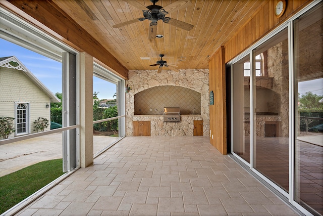 view of patio featuring ceiling fan, exterior kitchen, and a grill