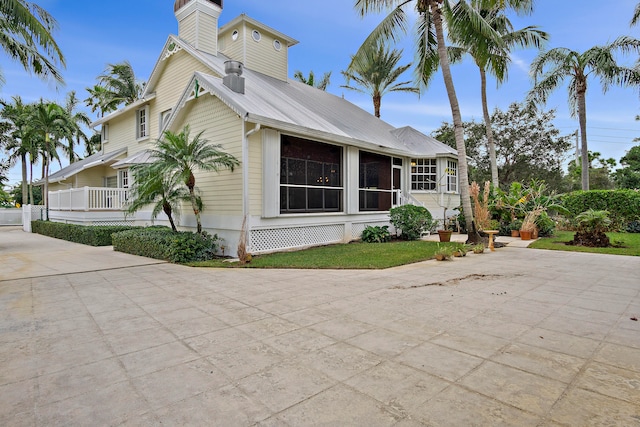 view of side of home featuring covered porch