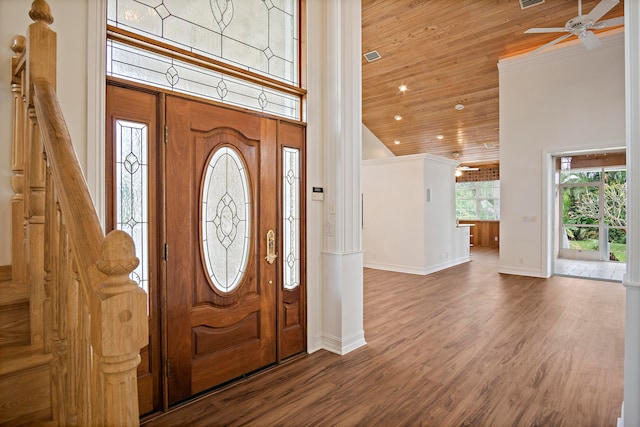 foyer entrance with wood ceiling, a towering ceiling, ceiling fan, and hardwood / wood-style floors