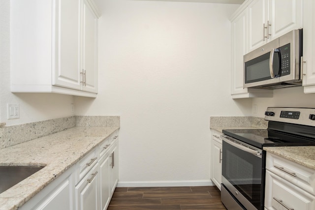 kitchen featuring light stone counters, white cabinets, stainless steel appliances, and dark hardwood / wood-style flooring