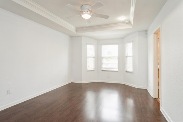 unfurnished room featuring ornamental molding, ceiling fan, a tray ceiling, and dark hardwood / wood-style flooring