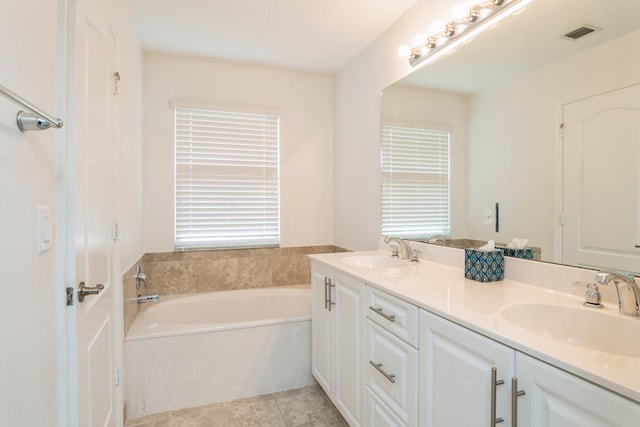 bathroom with vanity, a washtub, and tile patterned floors