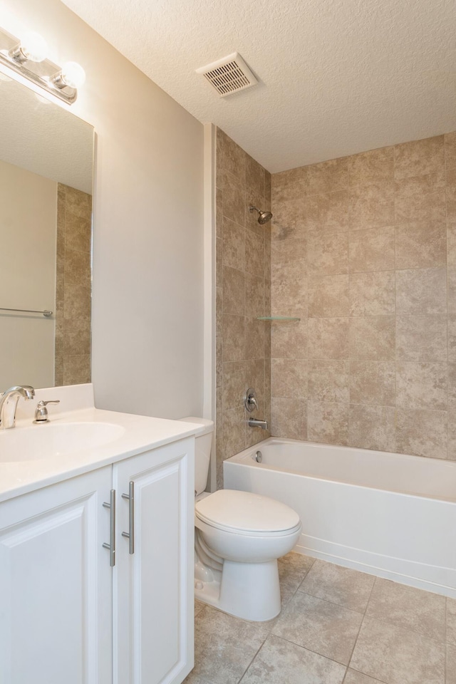 full bathroom featuring vanity, tiled shower / bath combo, toilet, and a textured ceiling