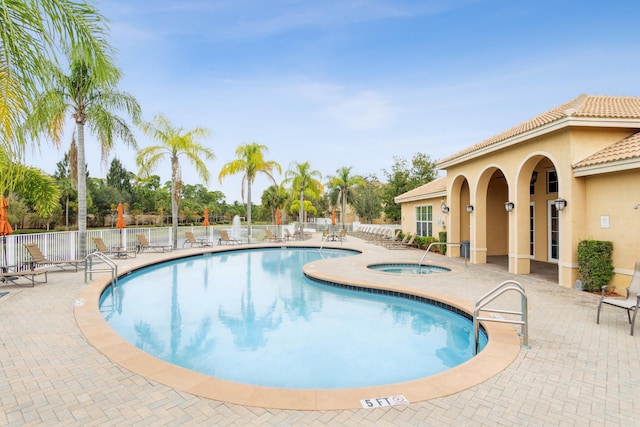 community pool with a patio, a community hot tub, and fence