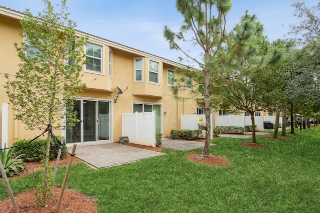 back of property featuring stucco siding, a yard, a patio area, and fence