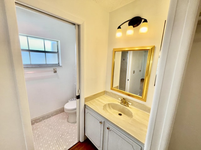 bathroom with baseboards, vanity, toilet, and tile patterned floors