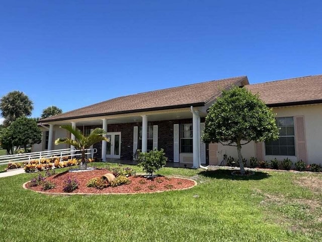 single story home featuring french doors, brick siding, fence, and a front lawn