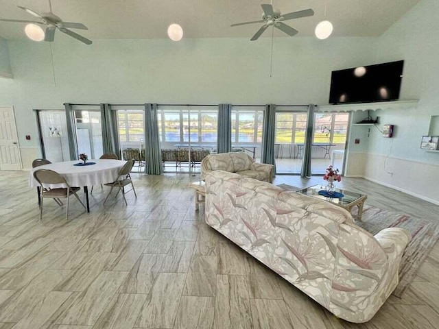 living room featuring ceiling fan, high vaulted ceiling, and a healthy amount of sunlight