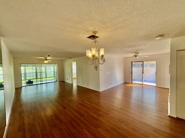 empty room featuring a textured ceiling, visible vents, wood finished floors, and ceiling fan with notable chandelier