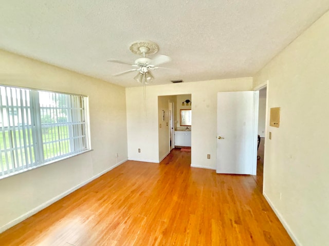 empty room featuring ceiling fan, a textured ceiling, and hardwood / wood-style floors