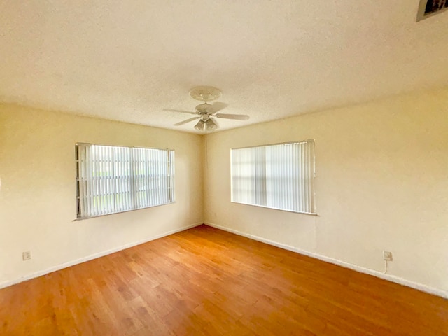 spare room featuring hardwood / wood-style flooring, ceiling fan, and a textured ceiling