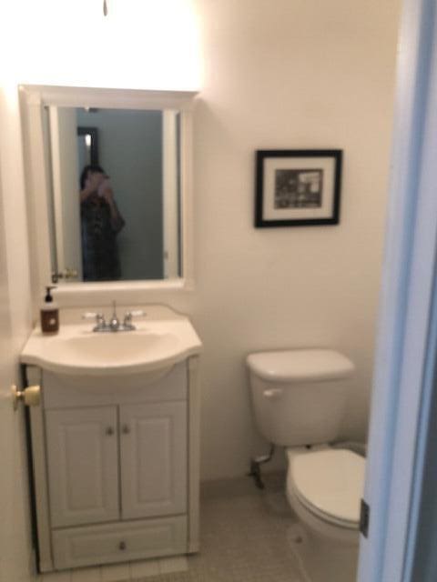 bathroom with tile patterned flooring, vanity, and toilet