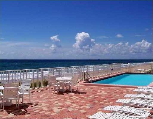 view of pool with a water view and a patio area