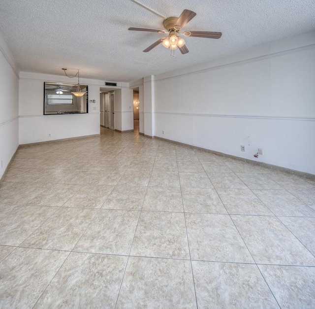 unfurnished room featuring ceiling fan and a textured ceiling