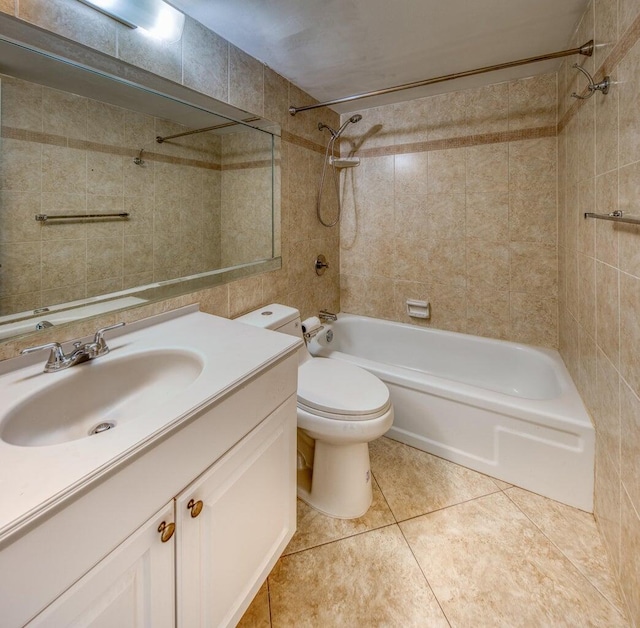 full bathroom with toilet, tile patterned floors, tile walls, tiled shower / bath combo, and vanity