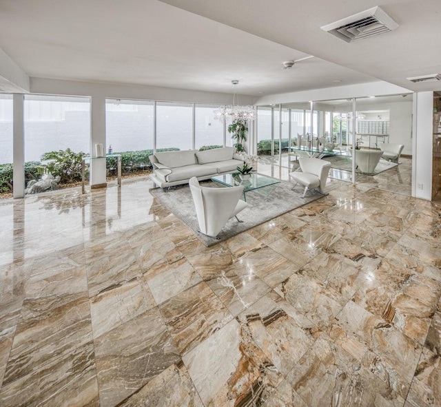 unfurnished living room with plenty of natural light and an inviting chandelier