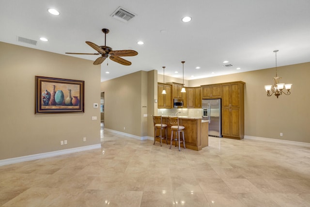 kitchen with appliances with stainless steel finishes, light stone countertops, decorative light fixtures, and a breakfast bar