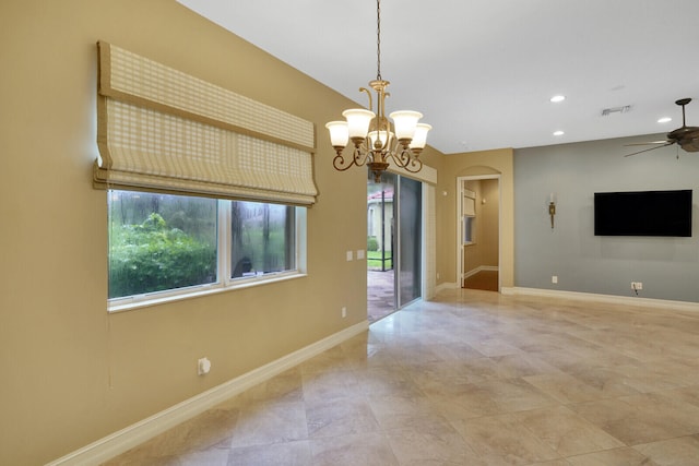 spare room featuring ceiling fan with notable chandelier