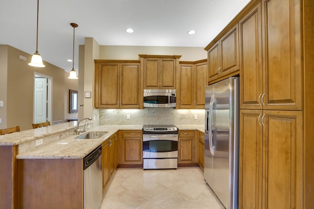 kitchen featuring hanging light fixtures, sink, kitchen peninsula, stainless steel appliances, and decorative backsplash