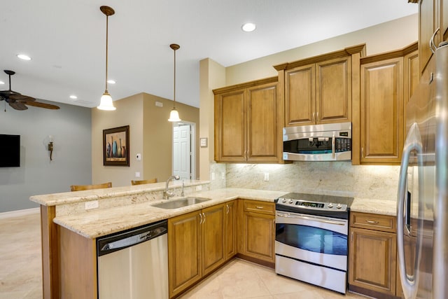 kitchen with stainless steel appliances, kitchen peninsula, hanging light fixtures, and sink