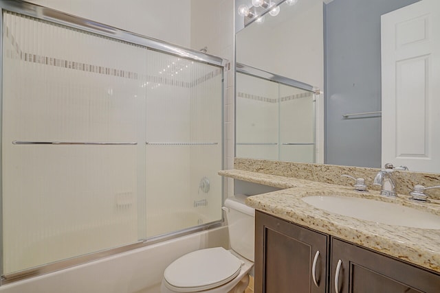 full bathroom featuring enclosed tub / shower combo, vanity, and toilet