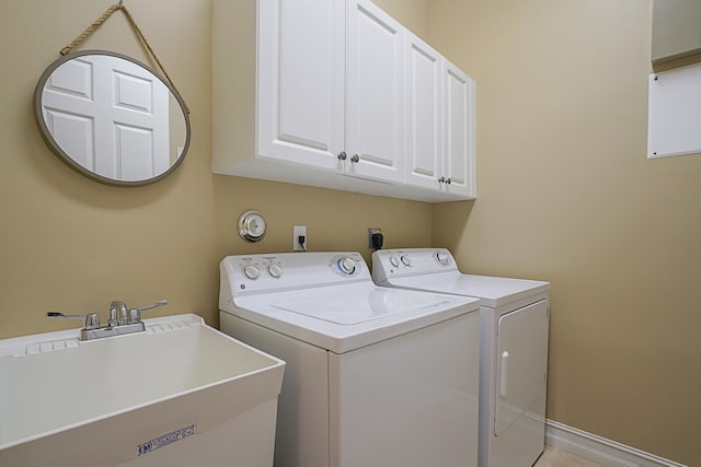 laundry area featuring cabinets, sink, and washer and dryer